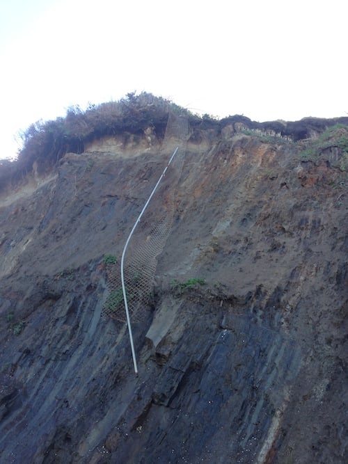 Fence line hangs precariously over the beach...watch out for falling objects!