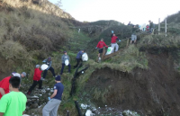 Southwestern Community College Volunteers form debris chains to remove debris from lighthouse beach