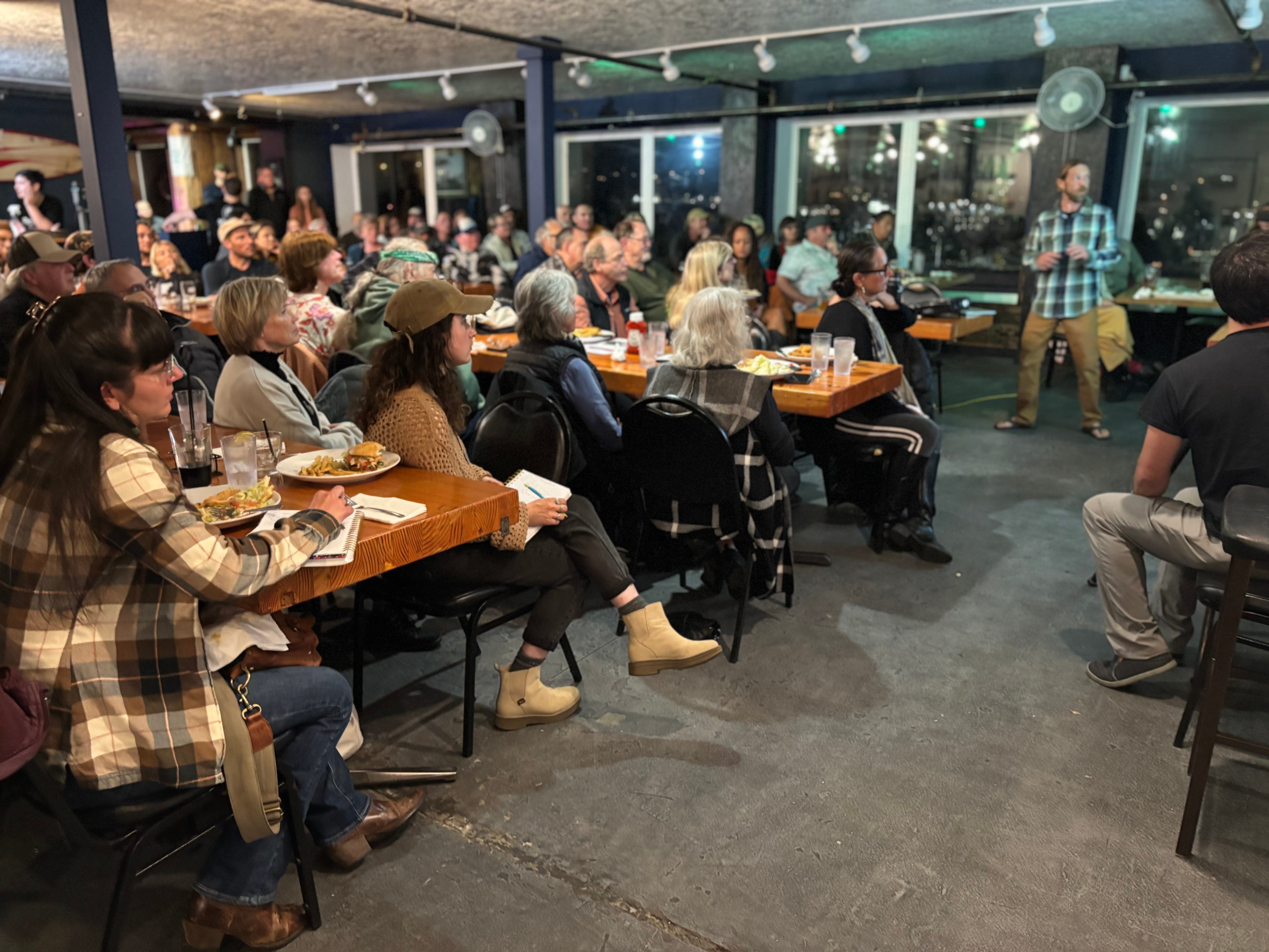 Photo of the community at the event with speaker presenting about the beach