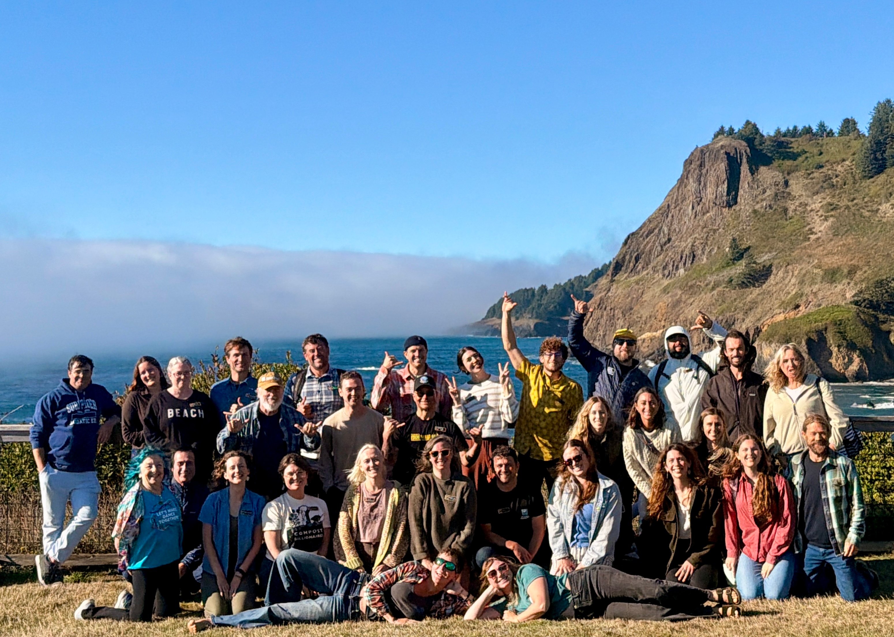 Conference attendees pose as a group in front of the Oregon bluff