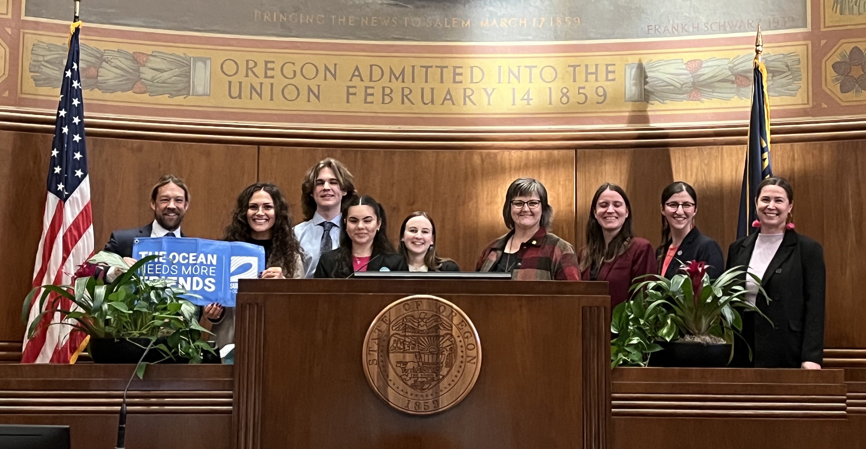 Individuals pose with Senator Sollman on the House floor at last year's Surfrider lobby day